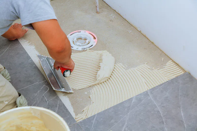 Un carreleur qui pose du carrelage