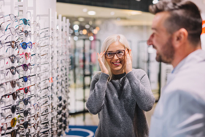 Un opticien avec une cliente pour des lunettes