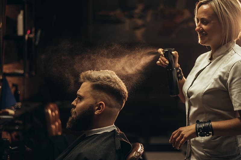 Un coiffeur dans son salon qui coiffe un client